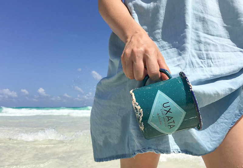 All-purpose jug from UXATA Private Chef Services, held by Chef Paula Alonso, on the seashore in Playa Paraíso, Riviera Maya, Mexico.